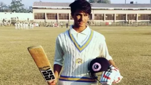 Young Abhishek Sharma wearing cricket whites and holding a bat and helmet at a local ground
