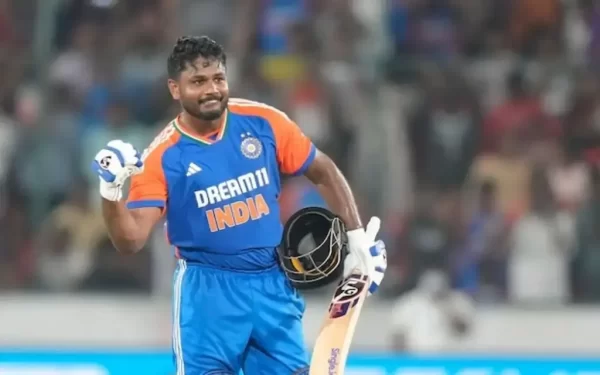 Sanju Samson celebrating an innings while holding his bat and helmet in India cricket kit.