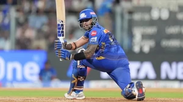 Suryakumar Yadav playing a sweep shot for Mumbai Indians during an IPL match.