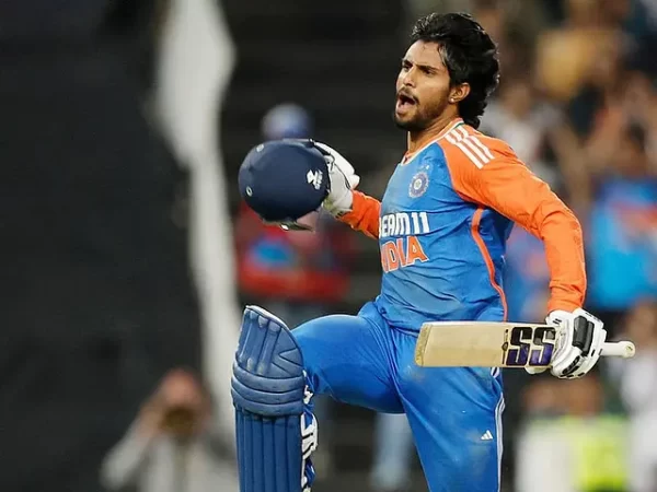 Tilak Varma celebrating with his bat and helmet while representing India in an international cricket match.