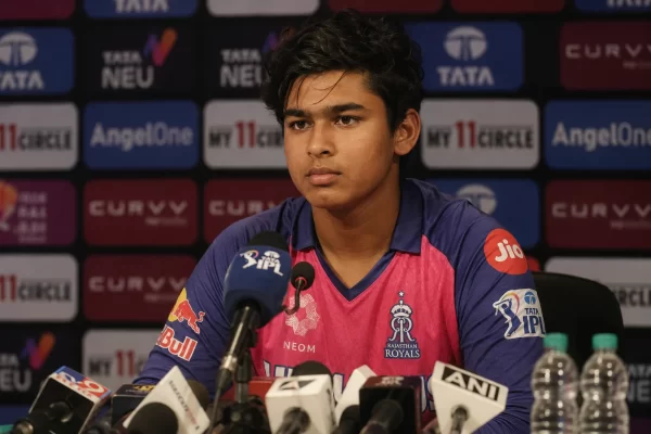 Vaibhav Sooryavanshi attends a press conference wearing a Rajasthan Royals jersey with microphones in front of him.